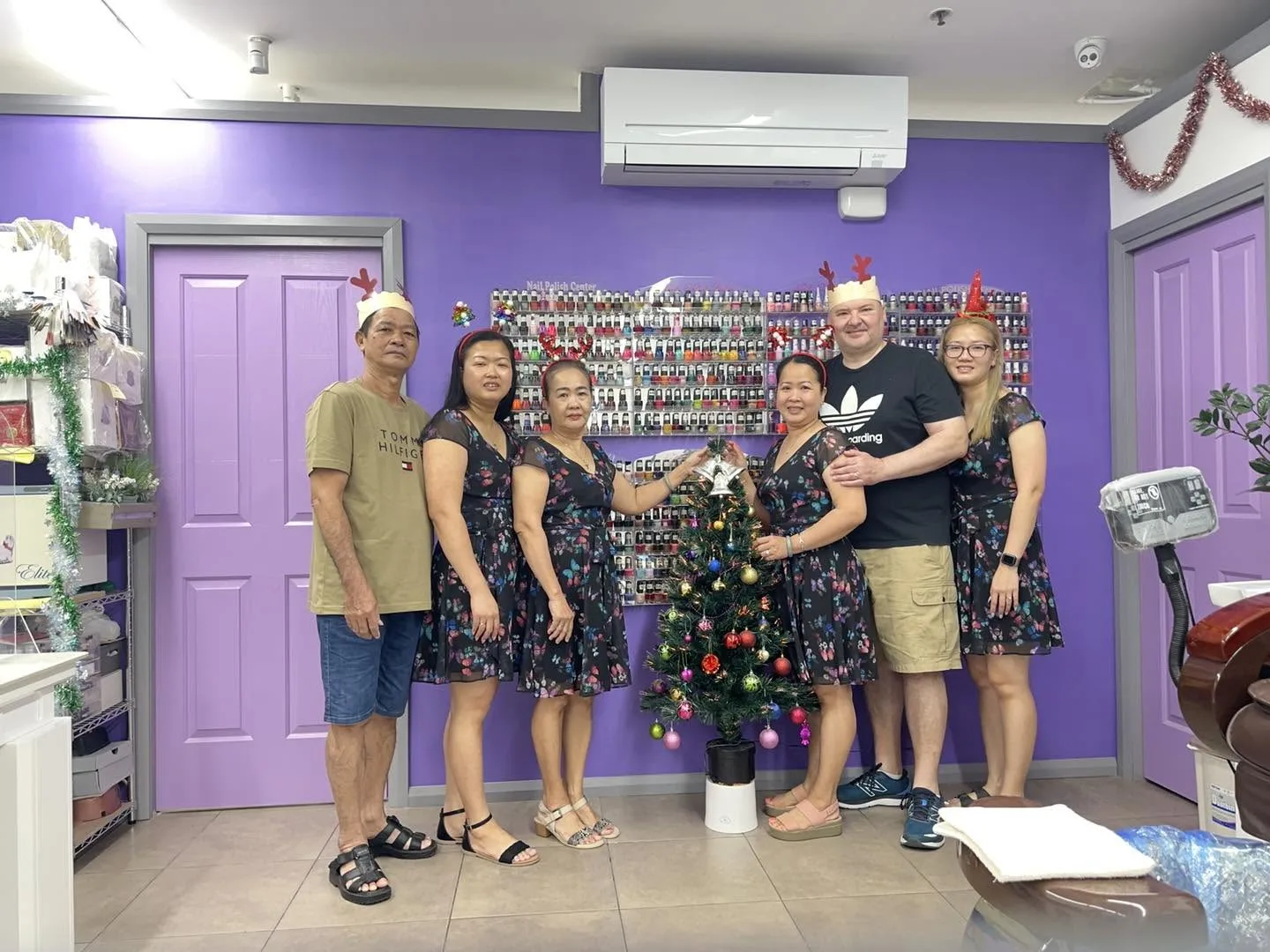 The Preston Nails & Lashes team together inside the salon, gathered in front of the Nail Polish Center colour wall