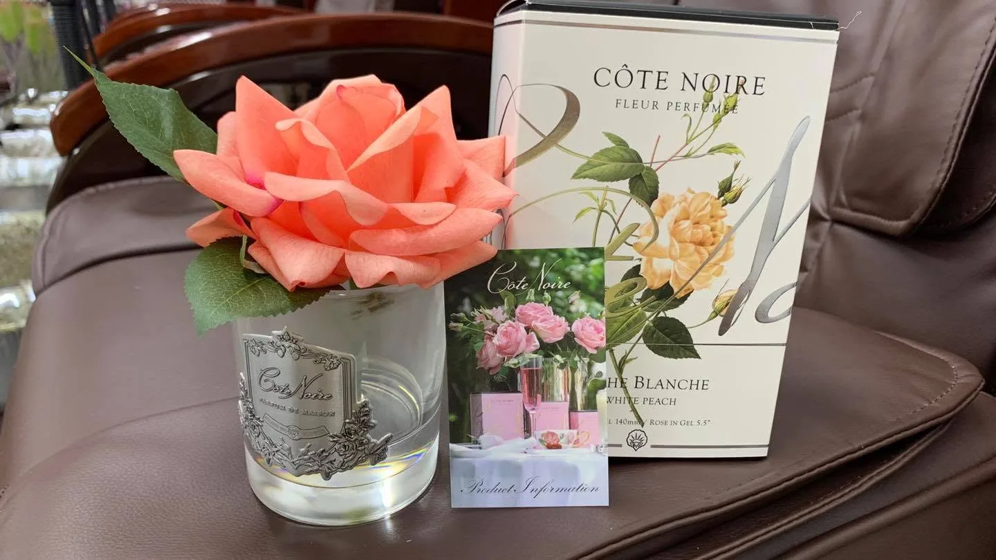 Côte Noire silver perfumed rose in coral with 'Fleur Perfumée / White Peach' box on a brown leather pedicure chair