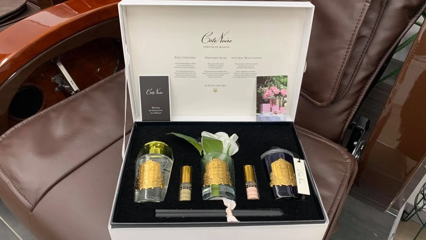 Open Côte Noire luxury gift set with diffuser, rose and candle in a tray on a brown pedicure chair