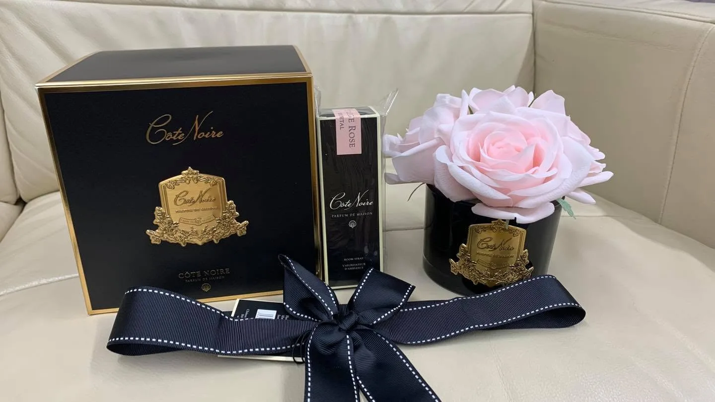 Côte Noire teal gift box with white perfumed rose and spray, teal bow, on a brown leather pedicure chair